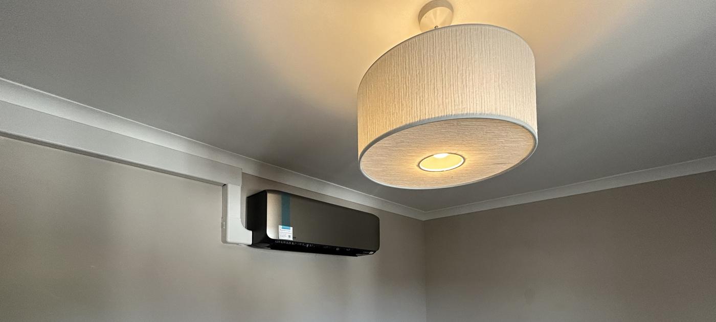 Black finish wall mounted unit with white trunking along the cornice
