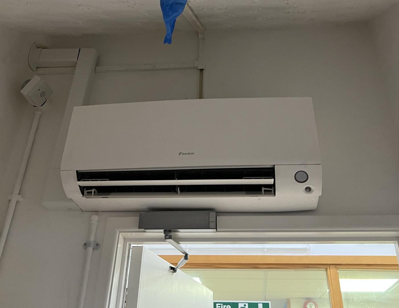 Daikin wall mounted unit with trunked pipework in a commercial building