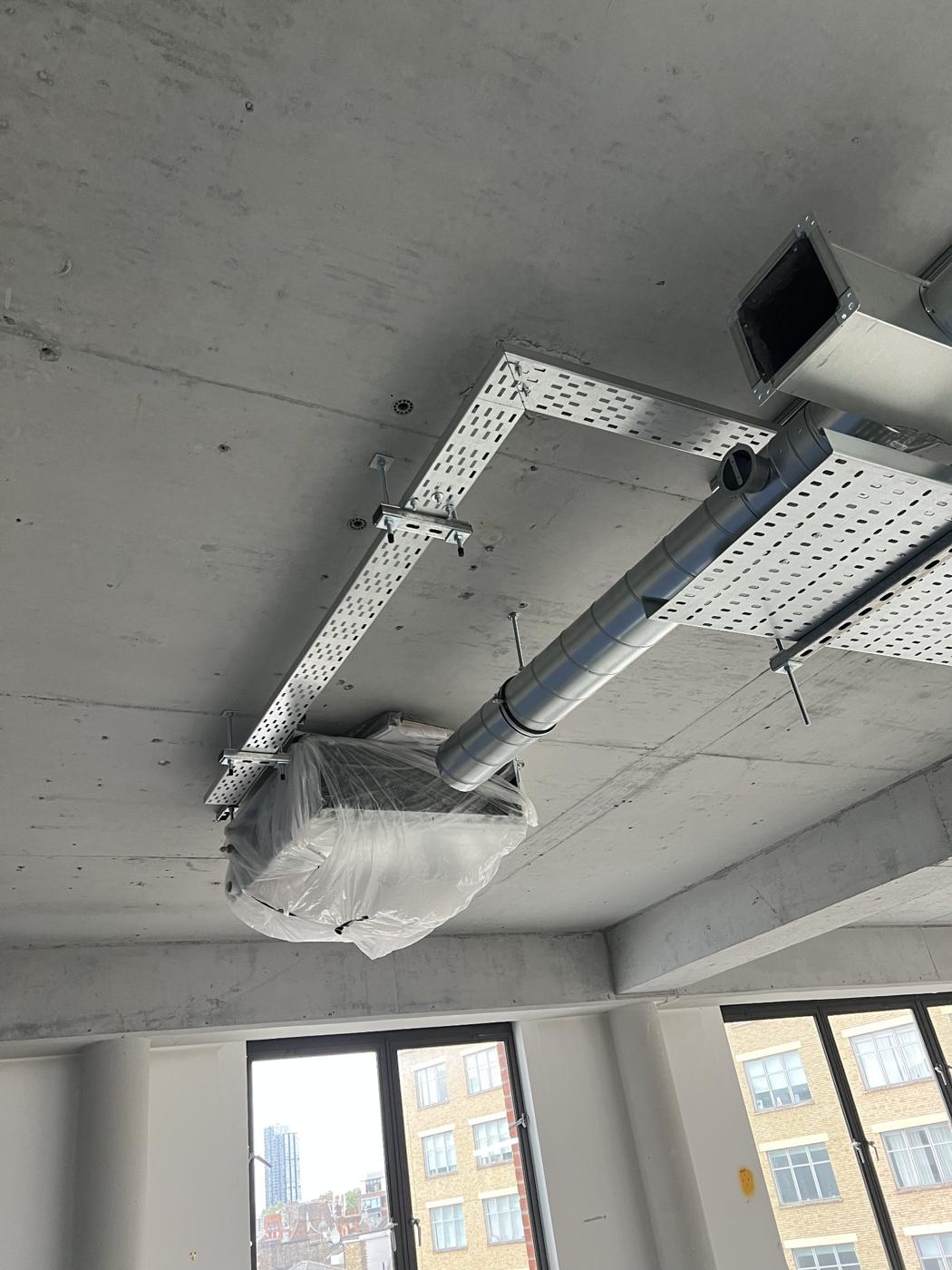 Ducted unit and containment in an exposed concrete ceiling