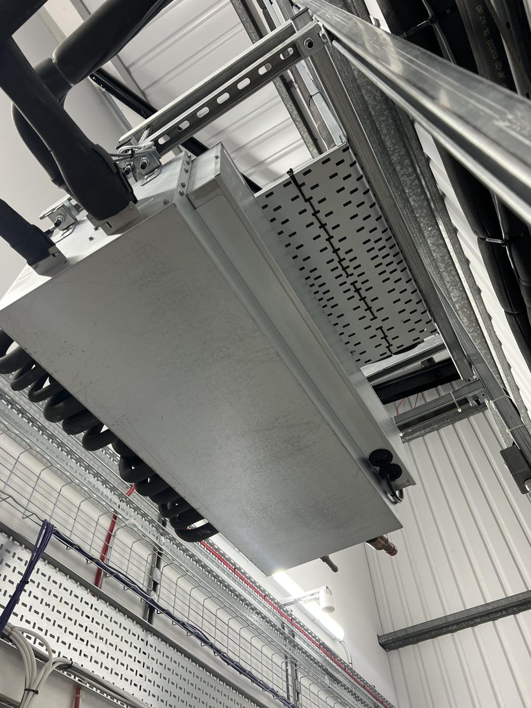 Ducted indoor unit supported on unistrut alongside containment