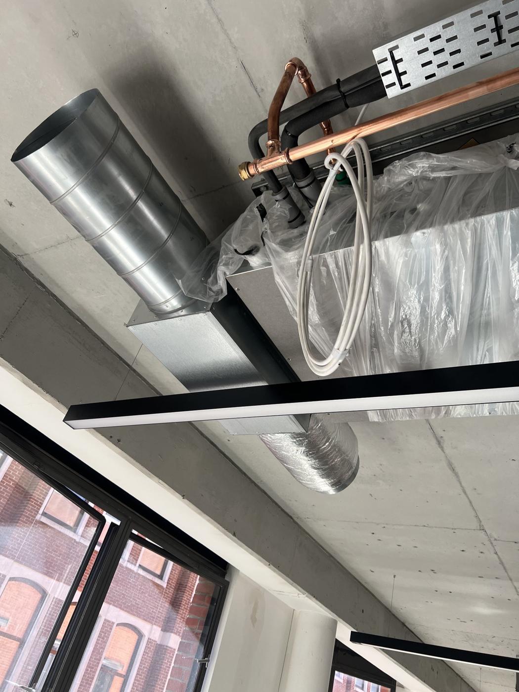 Ducted unit connected to spiral ductwork in an exposed concrete office