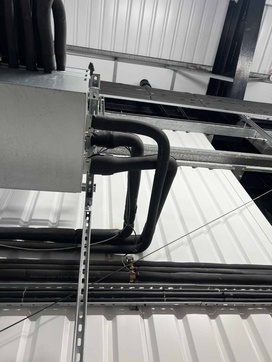 Insulated refrigerant pipework formed into neat sweeps
