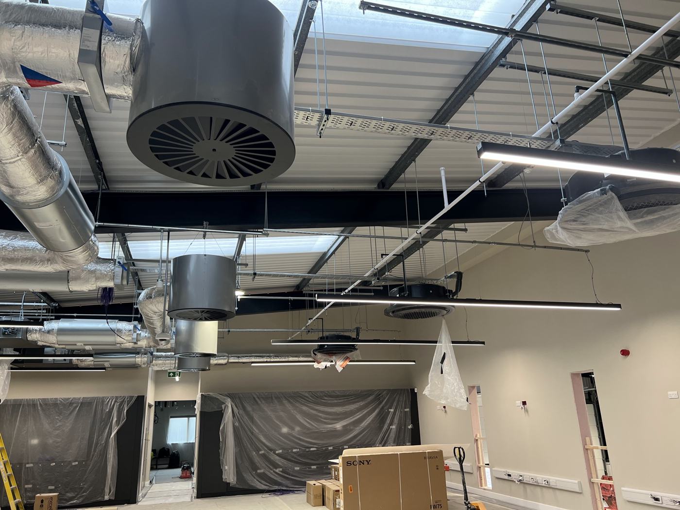 Open plan office fit out with exposed ductwork and indoor units at high level