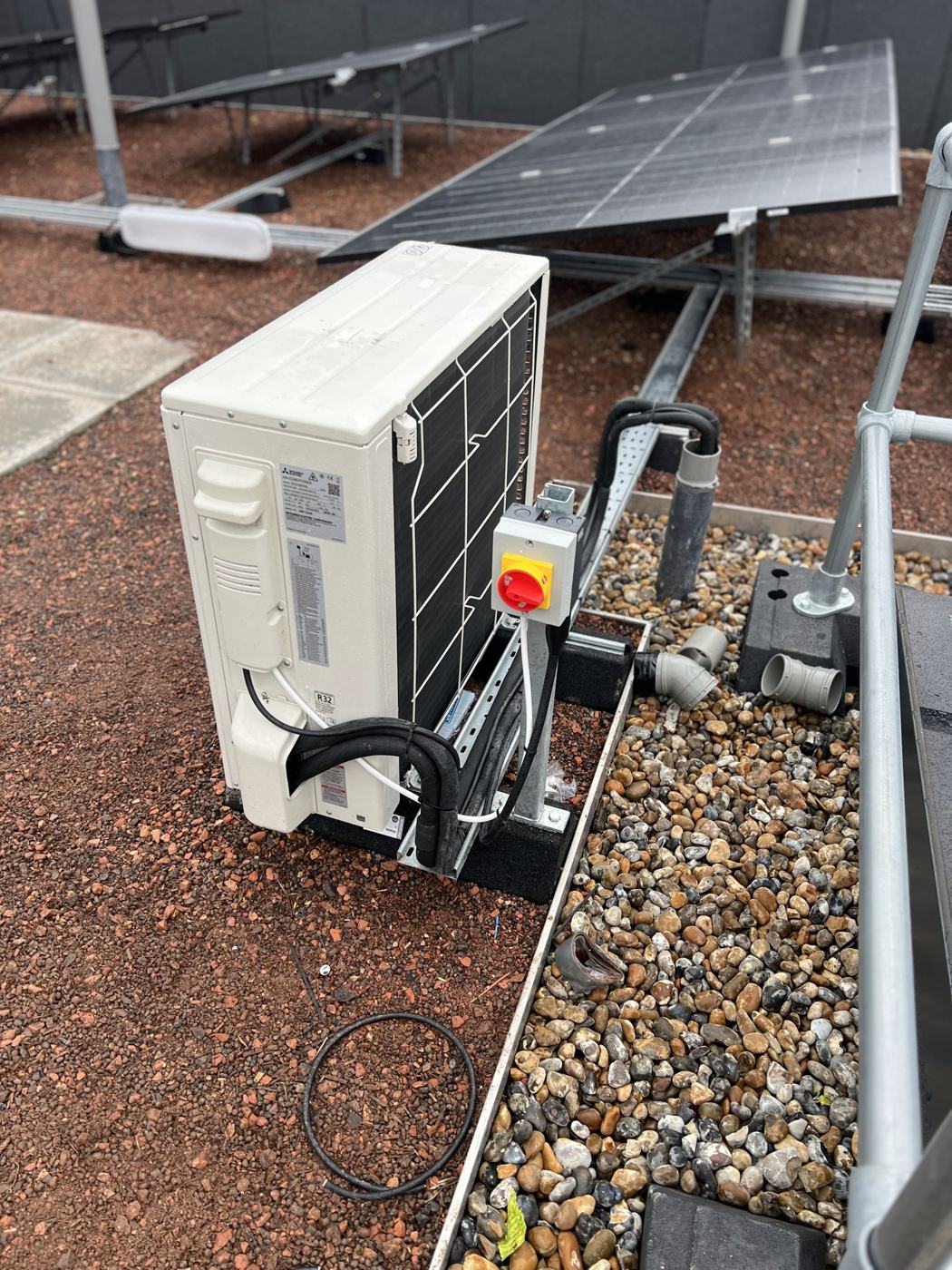 Outdoor unit on a green roof with isolator and containment