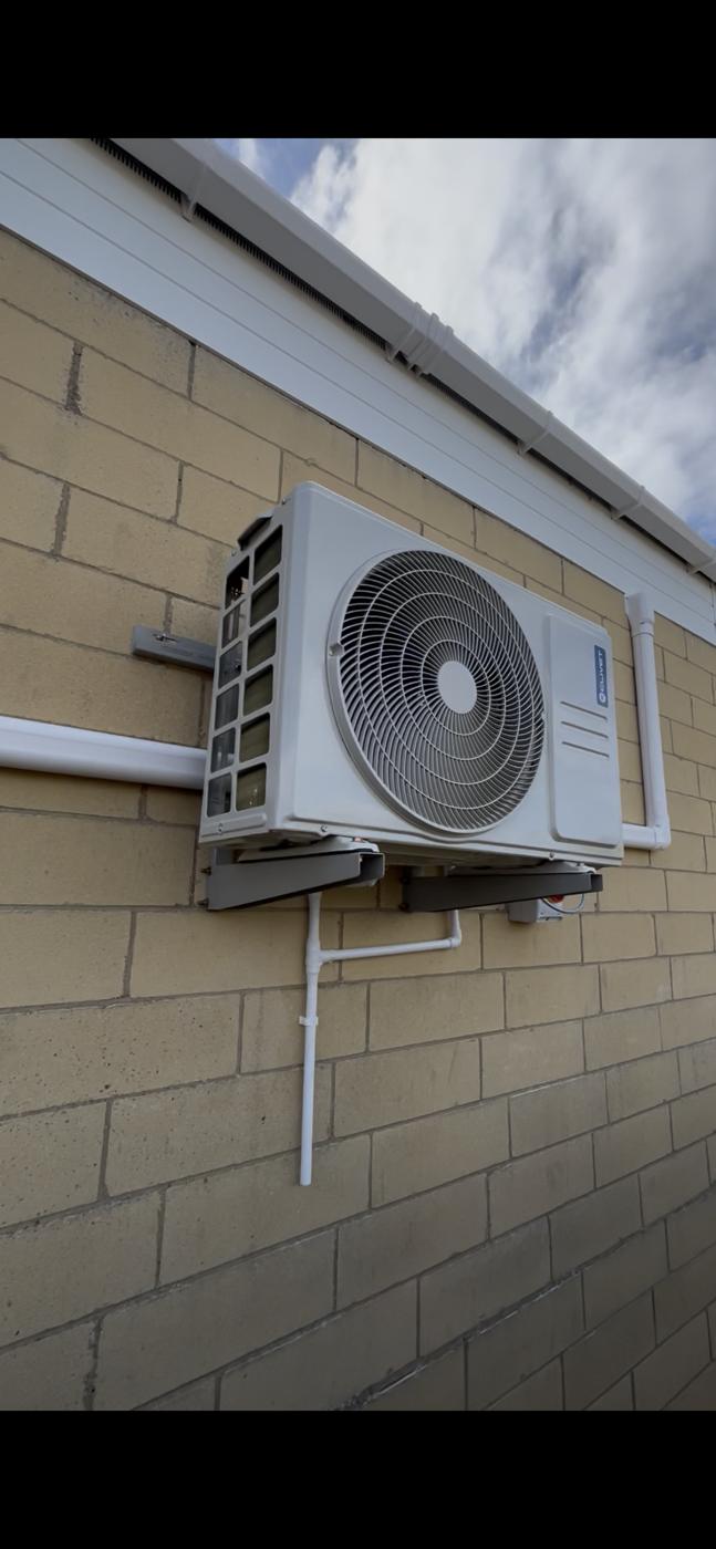 Outdoor unit on a wall bracket along a side passage