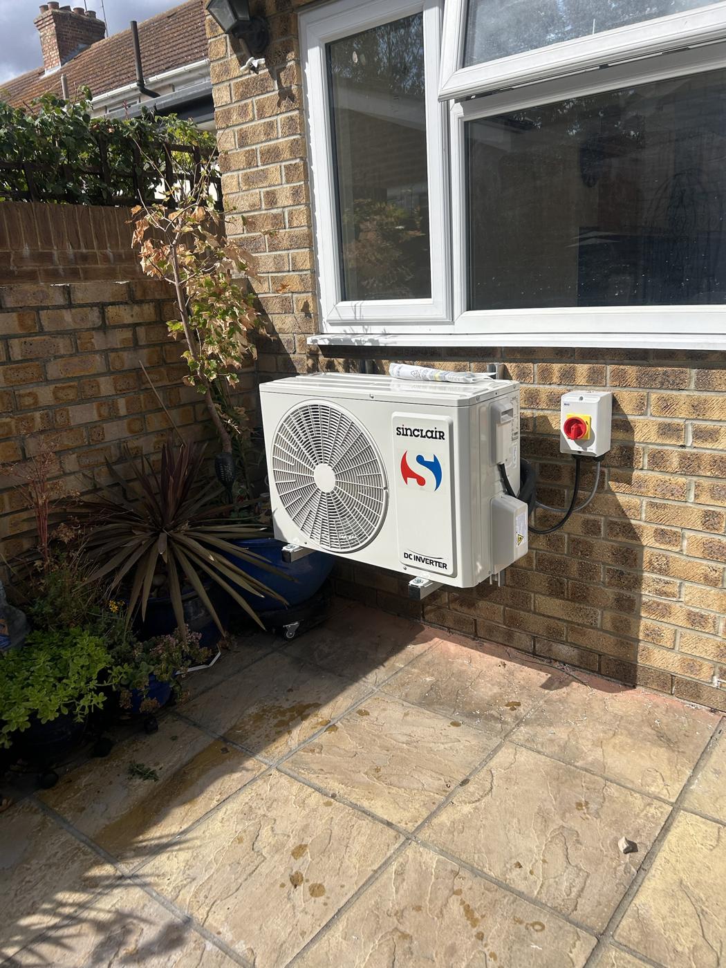 Sinclair outdoor unit on brackets with rotary isolator on a patio