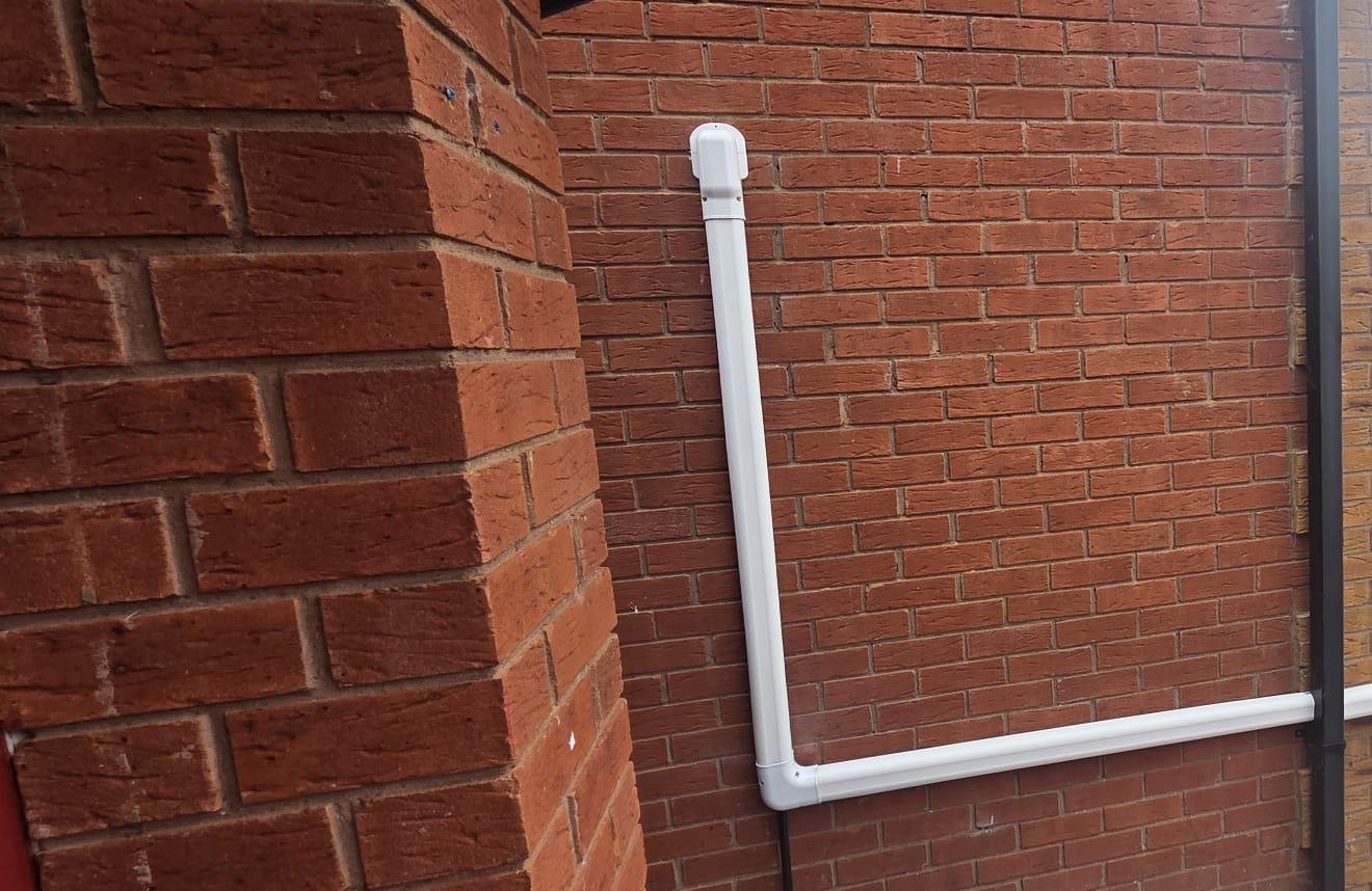 White trunking run cleanly across red brickwork to the outdoor unit
